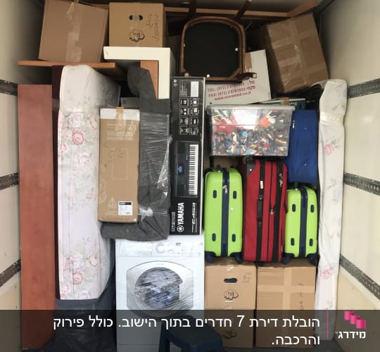 ארגזים, מזוודות ומכונת כביסה בתוך משאית הובלה
